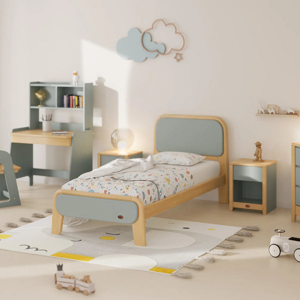 Children's bedroom with a bed, desk, and toys on a light-colored floor.