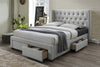 Grey upholstered bed with a diamond button tufted headboard with wings and 4 underbed storage drawers in a room setting.
