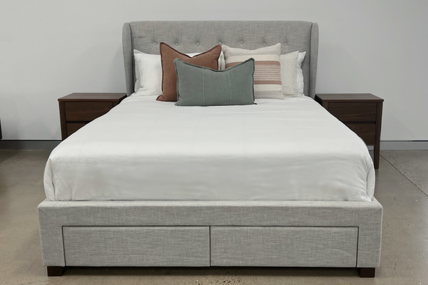 Light Grey winged and diamonded buttoned upholstered bed with storage drawers in a room with a walnut timber bedside tables