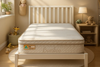 An Eco Kids Deluxe King SIngle Pillow Top Mattress pictured on a white timber bed frame with a slatted bedhead in a child bedroom setting with a teddy bear on a timber bedside table and a toy giraffe in a basket