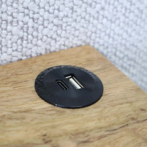 Black USB-A and USB-C ports on the Daintree Gas Lift Bed Frame bedside shelf shown in close up detail with the fabric headboard in the background