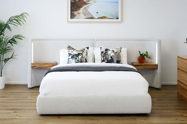 Modern Daintree gas lift storage bed in bedroom with a light grey bed, wooden nightstands, and a framed picture on the wall.