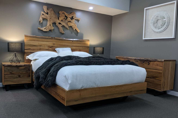 Modern hardwood bedroom with wooden bed and nightstands, gray walls, and decorative elements.