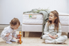 Two children playing with a toy in front of a mattress with an 'Eco Kids' brand label.