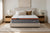 Morrison Bliss mattress styled front-on with linen and brown velvet cushions, twin bedside lamps and a sand-dune artwork above - a serene contemporary Australian bedroom