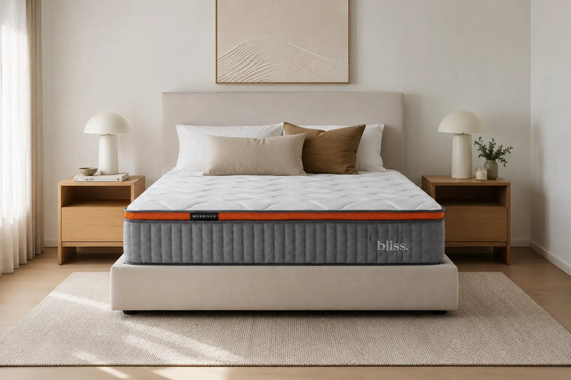 Morrison Bliss mattress styled front-on with linen and brown velvet cushions, twin bedside lamps and a sand-dune artwork above - a serene contemporary Australian bedroom