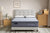 Morrison Good Morning mattress with quilted pillow-top and signature grey panel, styled in a warm contemporary bedroom with tufted linen bedhead, white pillows, timber dresser and floor lamp